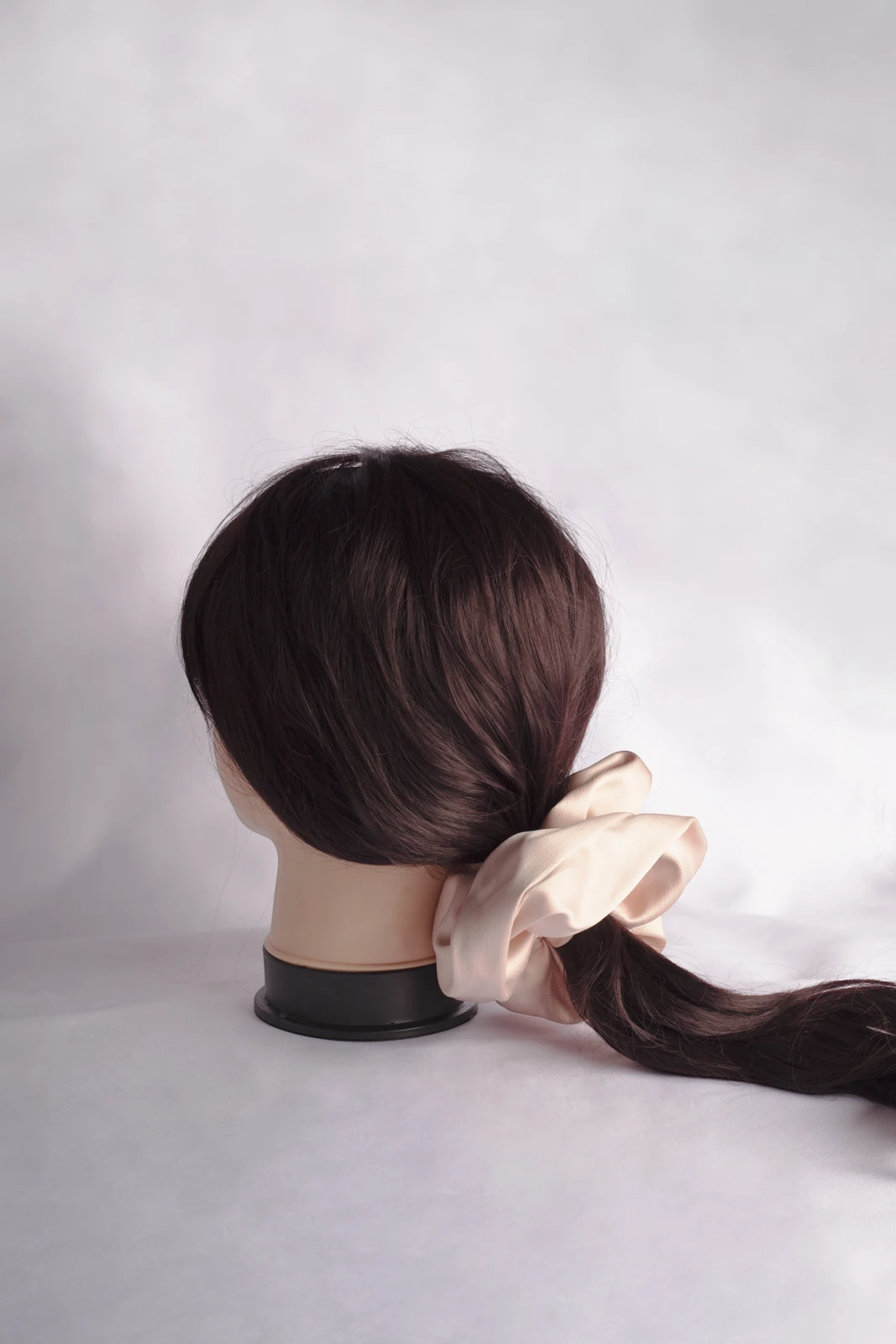 Mannequin with wig showing giant satin scrunchie tied in a low ponytail.